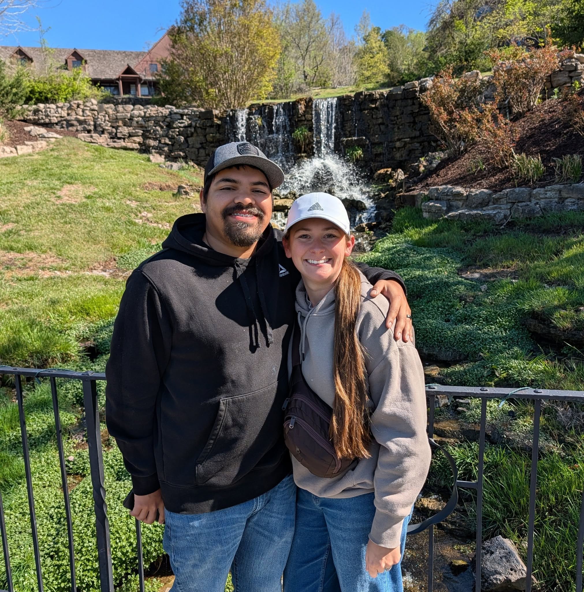 Jessica and her husband smiling in front of a waterfall